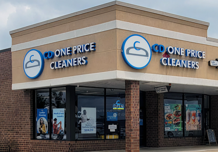 Exterior view of a CD One Price Cleaners retail location, showing the storefront and building where dry cleaning and laundry services are offered.