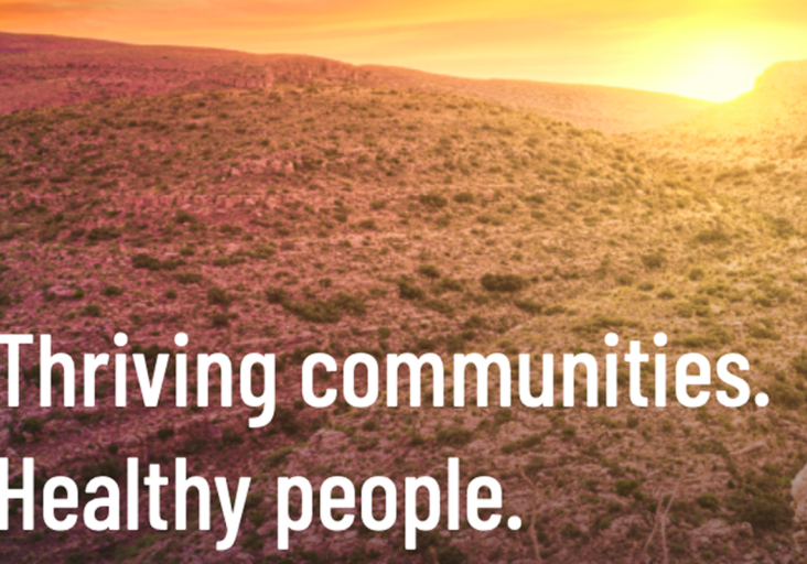 Sunlit desert hills at sunset with CHI-PHI’s tagline: Thriving communities. Healthy people.